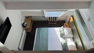 a small bedroom with a bed in a room at Le Cap Hornu in Saint-Valéry-sur-Somme