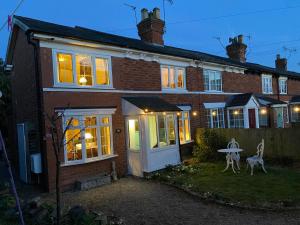 a brick house with a white door and a table at Butterfly Cottage in Knowle