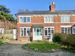 a red brick house with a white door at Butterfly Cottage in Knowle +16 photos