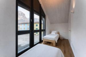 a bedroom with two beds and a large window at Valdastico Short Rentals in Maso +98 photos