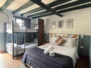 a bedroom with a bed and a bunk bed at Hotel Aceitunos in Villa de Leyva