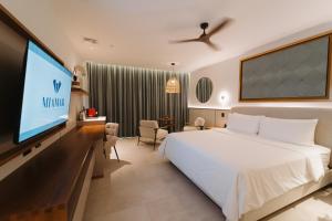a hotel room with a bed and a flat screen tv at Miamar in Manuel Antonio