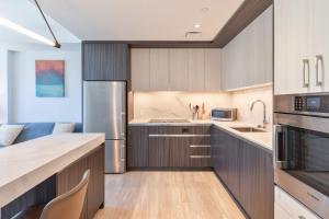 a kitchen with wooden cabinets and stainless steel appliances at Seaport Retreat - Rooftop Pool & Gym in Boston