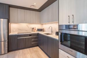 a kitchen with gray cabinets and stainless steel appliances at Seaport Retreat - Rooftop Pool & Gym in Boston