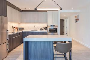 a kitchen with a blue island in the middle at Seaport Retreat - Rooftop Pool & Gym in Boston