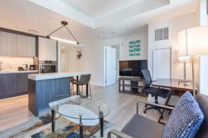 a living room and kitchen with a table and chairs at Seaport Retreat - Rooftop Pool & Gym in Boston +5 photos