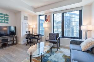 a living room with a couch and a table at Seaport Retreat - Rooftop Pool & Gym in Boston
