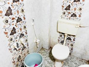 a bathroom with a toilet and a trash can at Sri Seshadri Rest House in Avanigadda
