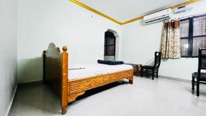 a bedroom with a bed and a table and chairs at Sri Seshadri Rest House in Avanigadda