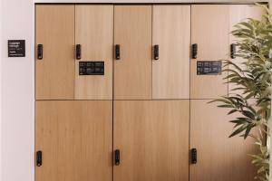 a row of lockers in a building with a plant at Aspasios Sofia Atocha Aparthotel in Madrid +23 photos