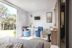 a bedroom with blue chairs and a table and a window at Camping Le Marqueval in Pourville-sur-Mer +83 photos