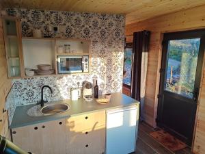 a kitchen with a sink and a counter top at The Perch - Romantic Cabin with Sunset Views in Gurteenulla