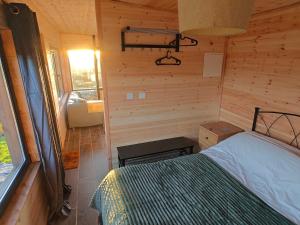 a bedroom with a bed in a wooden cabin at The Perch - Romantic Cabin with Sunset Views in Gurteenulla