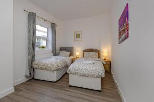 a bedroom with two beds and a window at Blue Horizon Seaside Apart in Clacton-on-Sea
