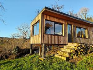 a wooden cabin with windows on a hill at The Perch - Romantic Cabin with Sunset Views in Gurteenulla