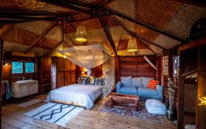 a bedroom with a bed and a couch in a room at Mansa Musso Lodge in Sanyang