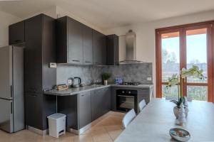 a kitchen with gray cabinets and a table with a dining room at Relais Terre Divino 2 in Ponton