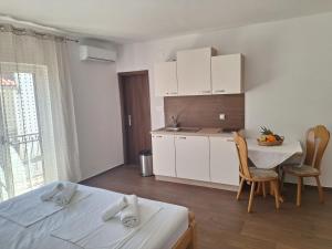 a room with a kitchen and a table with chairs at Apartments Dalmacija in Podstrana
