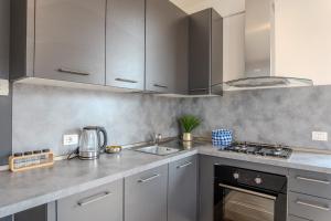 a kitchen with gray cabinets and a stove top oven at Relais Terre Divino 2 in Ponton +18 photos