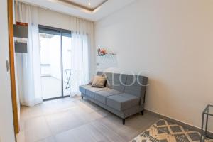 a living room with a couch and a large window at Dassine View - Luxe - Agadir - 4 Px in Agadir