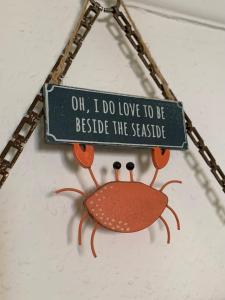 a sign that says oil i do love to be beside the parasite at Charming Cottage and Beach Hut in Cromer