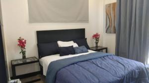 a bedroom with a bed and two tables with flowers at Ocean View House, Modern, Elegant with Pool in Coco