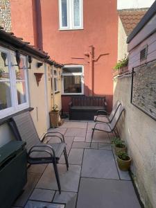 a patio with two chairs and a couch at Charming Cottage and Beach Hut in Cromer