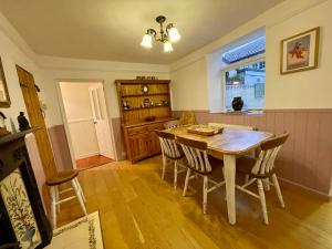 a dining room with a wooden table and chairs at Charming Cottage and Beach Hut in Cromer