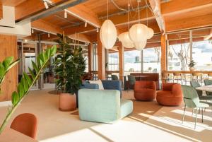 a lobby with colorful chairs and tables and windows at Kora Olea in Torremolinos
