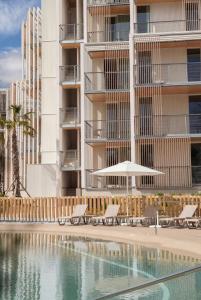 a hotel with a swimming pool in front of a building at Kora Olea in Torremolinos