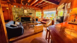 a living room with a couch and a fireplace at Viejo Radal "Casa de Montaña" in San Martín de los Andes