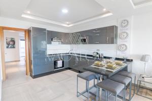 a kitchen with a island with chairs and a table at Dassine View - Luxe - Agadir - 4 Px in Agadir