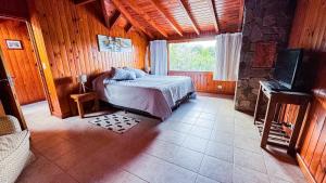 a bedroom with a bed and a television in a room at Viejo Radal "Casa de Montaña" in San Martín de los Andes