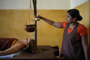 a woman is giving a woman a basket at DrUnni's Ayurveda Resort in Kovalam +18 photos