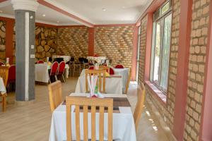 a restaurant with tables and chairs in a room at Premier motel in Bushenyi