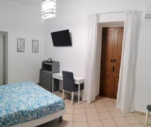 ein Schlafzimmer mit einem Bett und einem Schreibtisch mit Computer in der Unterkunft Civico56 in Patti