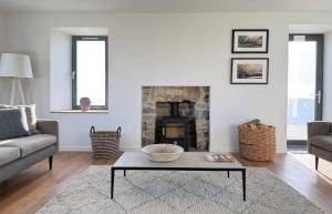 a living room with a couch and a fireplace at Taigh Druim in Elgol