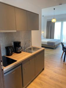 a kitchen with a sink and a couch in a room at SunSea Studios close to the beach in Kato Gouves