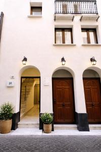 two entrances to a white building with wooden doors at Noor Palace - PI Collection Hotel in Palermo