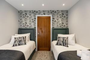 two beds sitting next to each other in a room at New Apartment in Guildford in Guildford