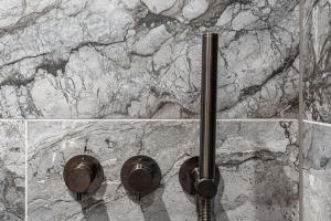 a bathroom with a stone wall with a shower at New Apartment in Guildford in Guildford