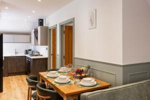 a dining room table with chairs and a kitchen at New Apartment in Guildford in Guildford +25 photos