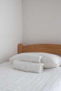 three white pillows sitting on top of a bed at Hillside Apartments in Sutorina