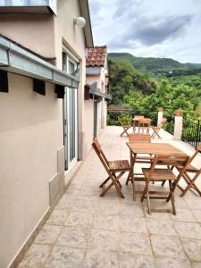 a patio with a wooden table and chairs on a balcony at Hillside Apartments in Sutorina