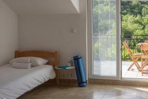 a bedroom with a bed and a large window at Hillside Apartments in Sutorina