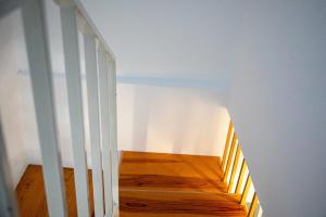 a staircase in a room with white walls and wooden floors at GuestReady - Beachside house with ocean view in Ponta Delgada +35 photos