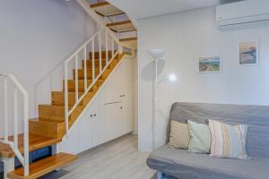 a living room with a staircase and a couch at GuestReady - Beachside house with ocean view in Ponta Delgada