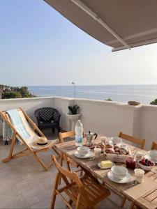 a wooden table with food on a patio with the ocean at Crisvan Home in Capo Rizzuto