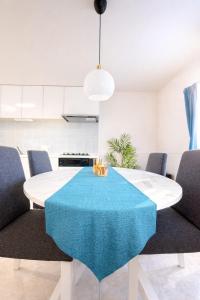 a white dining room with a blue table and chairs at Sunstone Residence 2F - Free Rental Car & Airport Pickup - 10 Min to American Village in Ginowan +42 photos