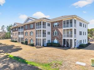an exterior view of a large apartment building at 2BR Condo with Golf Views Near Sunset Beach in Sunset Beach